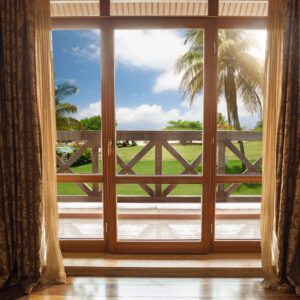 Closed window and beautiful picture outside, nature view, resort and resting. Sunny summers or spring day with green grass, sea or ocean, bright and vibrant colors. Tourism, hotels or home mood.
